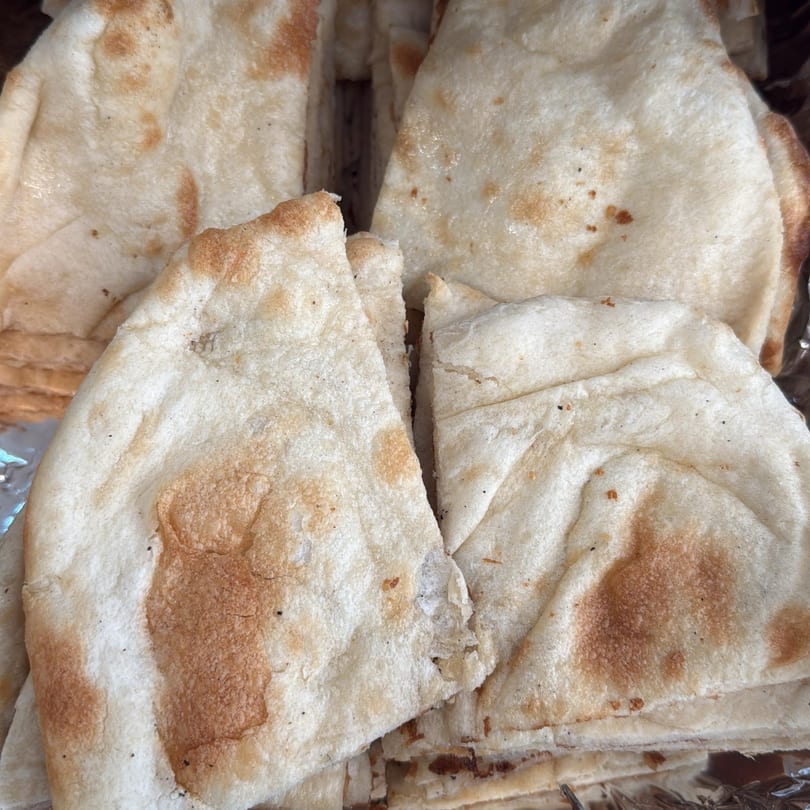 Close-up of several pieces of Kathmandu Restaurant's freshly baked, lightly browned naan bread.